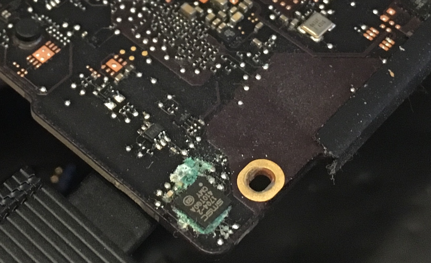 Blue corrosion surrounding an IC on the bottom of the board